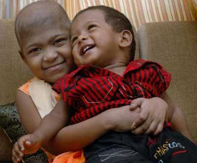 Two young children laughing and embracing — thriving after thalassemia treatment and BMT